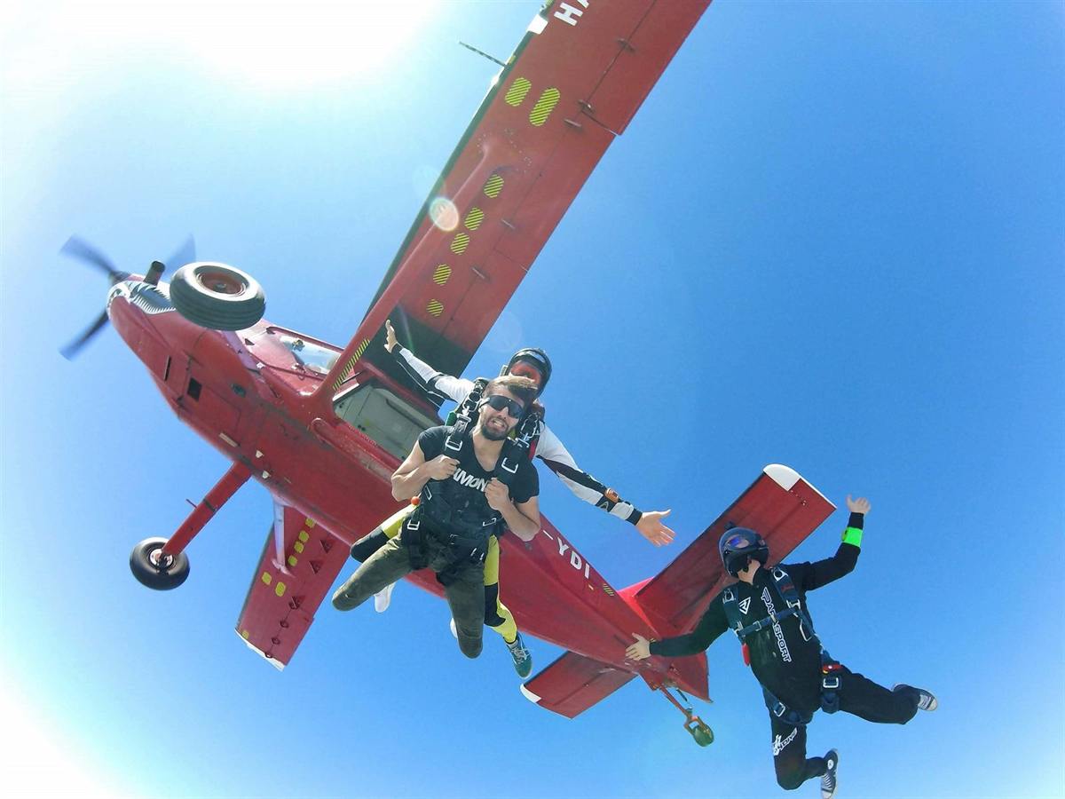 Salto tándem saliendo del avión, con un camarógrafo al lado
